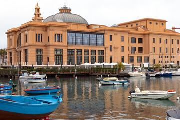 Margherita Theater and fishing boats in old harbor of Bari, Puglia, Italy.