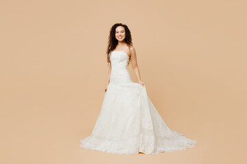 Full body smiling gorgeous beautiful happy young woman bride wear wedding dress posing look camera...