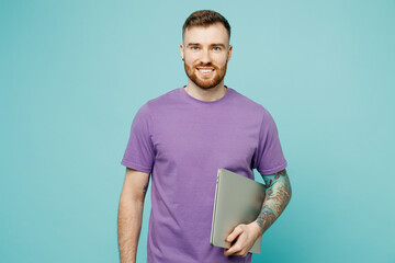 Young confident fun cheerful happy programmer smart IT man he wear purple t-shirt hold closed...