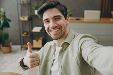 Close up young man wear shirt casual clothes doing selfie shot pov on mobile cell phone show thumb...