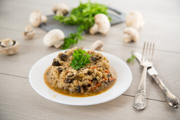cooked bulgur with mushrooms, carrots and vegetables in a plate