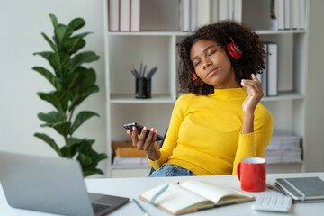 Startup businesswoman, American woman African woman wearing headphones music and holding mobile...