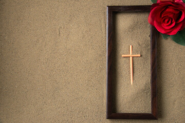 top view of stick cross with red flower on the sand palestine funeral