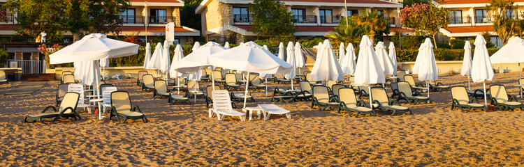 beach scene in Side Turkey with empty umbrellas and sun loungers. Vacation at the sea. Summer holidays.