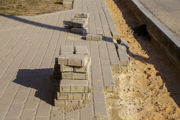 The process of building and repairing a sidewalk paved with brick, a half-built sidewalk road. Sidewalk construction.