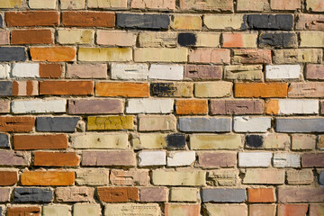 Brickwork of a wall of multi-colored bricks