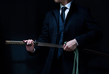 スーツ姿で刀を構える人物（The man holding katana and wearing suits）