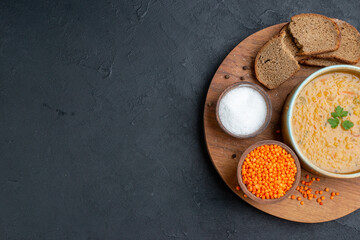 top view lentil soup with salt raw lentils and dark bread loafs on dark surface diner dinner food bread horizontal dish colourful free space