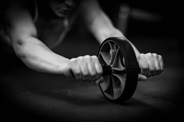 Woman Doing Exercise with Abs Roller Wheel in The Gym, black and white