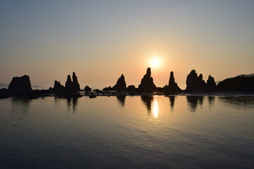 早朝の海岸に立つ奇岩