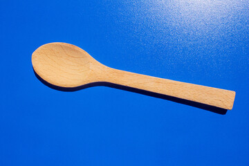 Wooden spoon isolated on blue background
