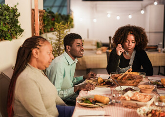 African family eating healthy vegetarian dinner at home patio during night time - Soft focus on the boy face