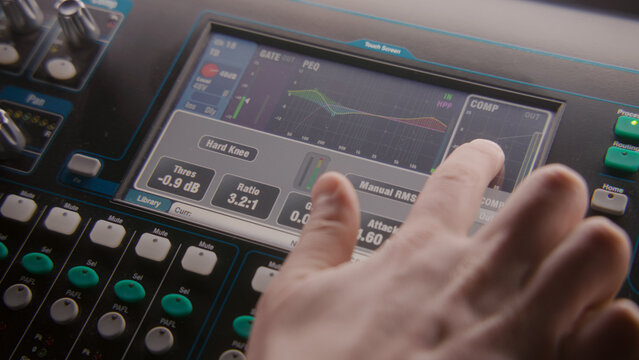 Close up shot of mixing console, remote control for adjusting sound, audio mixer. Small digital touch screen with diagram and sound settings. Modern sound recording studio equipment. Music production.