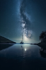 A modern sailing yacht floats on the waves against the background of a starry night sky. AI Generated