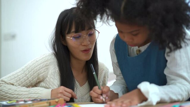 African - American ethnic little girl enjoy drawing and painting with her sister. 