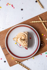 top distant view cake slice inside plate with candles all over the light desk cake sweet sugar