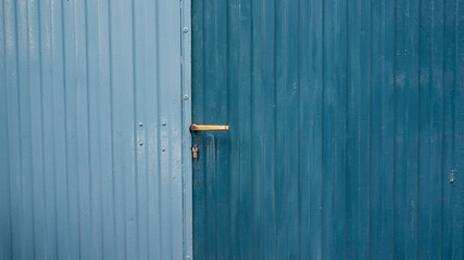 Puerta de metal corrugado en dos tonos de azul