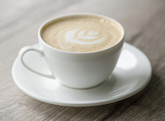 Cup of hot cappuccino coffee on table