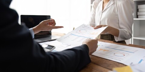 Multicultural professional businesspeople working together on research plan in boardroom