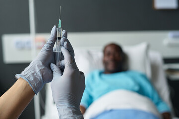 Close-up of nurse in protective gloves holding syringe in hands to make vaccination to patient in...