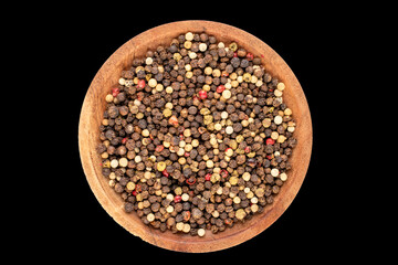 A mixture of four peppercorns on a wooden saucer, macro, isolated on a black background, top view