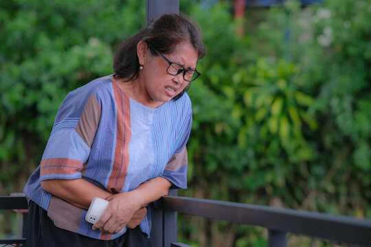 A middle-aged woman is having a stomachache
