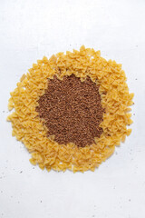 top view yellow raw pasta little formed with buckwheat on the white desk pasta italy food meal