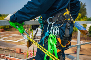 Closeup male worker standing on tank male worker height roof tank knot carabiner rope access safety