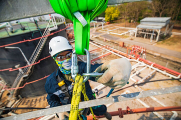 Closeup male worker standing on tank male worker height roof tank knot carabiner rope access safety