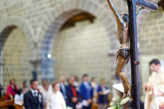 Statua di Ges&ugrave; Cristo in primo piano durante una celebrazione di nozze in un ahciesa cattolica 