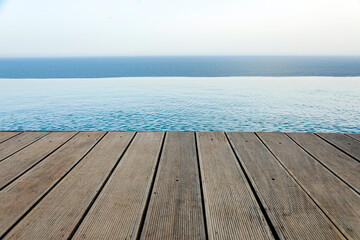 bordo in legno di una piscina che si proietta a strapiombi sul mare - obrazy, fototapety, plakaty