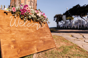 cartello in legno che indica la scritta "welcome" e intorno una fantastica decorazione floreale © alex.pin