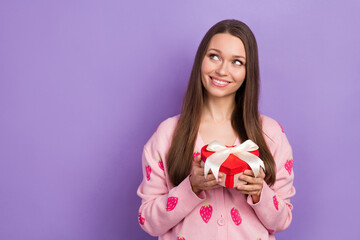 Photo of dreamy pretty lady dressed strawberry print cardigan holding present box looking empty space isolated purple color background