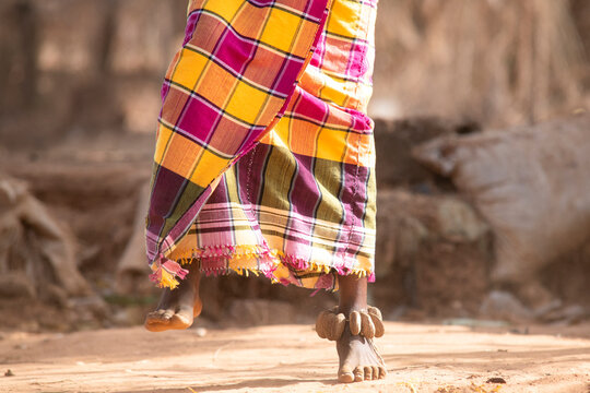 Unrecognizable black girl dancing on dusty ground
