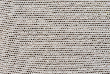 Close-up of cream-colored knit fabric for backgrounds and designs.