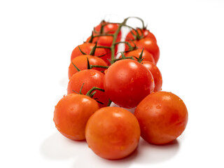 Bunch of fresh red tomatoes with green stems isolated on white background. Tomatoes close-up.