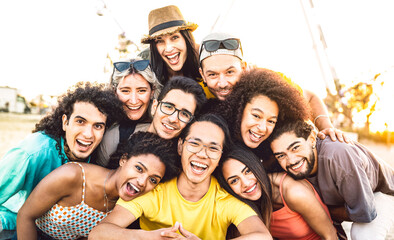 Multi racial diverse friends taking selfie at beach party festival - Happy life style and summer holidays concept on trendy generation people having fun day together out side - Vivid backlight filter