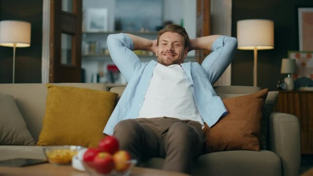 Handsome guy chilling couch cozy living room. Carefree man relaxing in evening