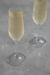 Cold Bubbly Champagne in a Glass on a gray background, side view.