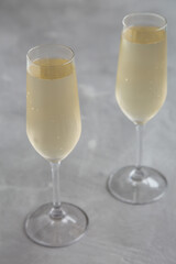 Cold Bubbly Champagne in a Glass on a gray background, side view.