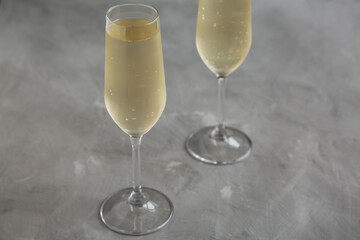Cold Bubbly Champagne in a Glass on a gray background, side view.