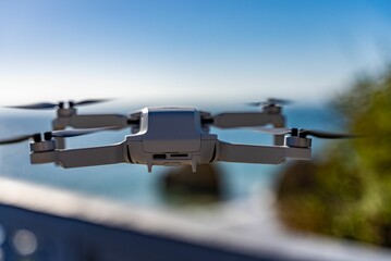 Close-up shot of a small Camera drone on a mid-flight on a blurred background