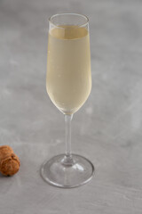 Cold Bubbly Champagne in a Glass on a gray background, side view.