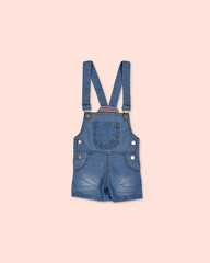 Children's denim overalls with suspenders isolated on pastel background.