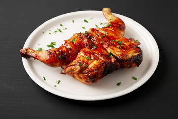 Homemade Spatchcocked Grilled Piri-Piri Chicken with Parsley on a Plate, side view.