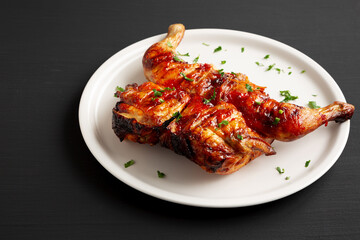 Homemade Spatchcocked Grilled Piri-Piri Chicken with Parsley on a Plate, side view. Copy space.