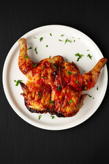 Homemade Spatchcocked Grilled Piri-Piri Chicken with Parsley on a Plate, top view. Overhead, from above, flat lay.