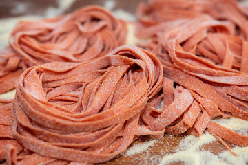 Pasta fresca tallarines al huevo con masa de pimiento rojo.