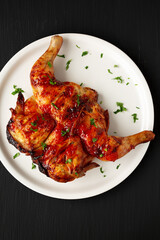Homemade Spatchcocked Grilled Piri-Piri Chicken with Parsley on a Plate, top view. Overhead, from above, flat lay. Close-up.