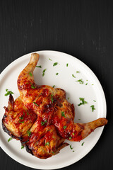 Homemade Spatchcocked Grilled Piri-Piri Chicken with Parsley on a Plate, top view. Overhead, from above, flat lay. Copy space.